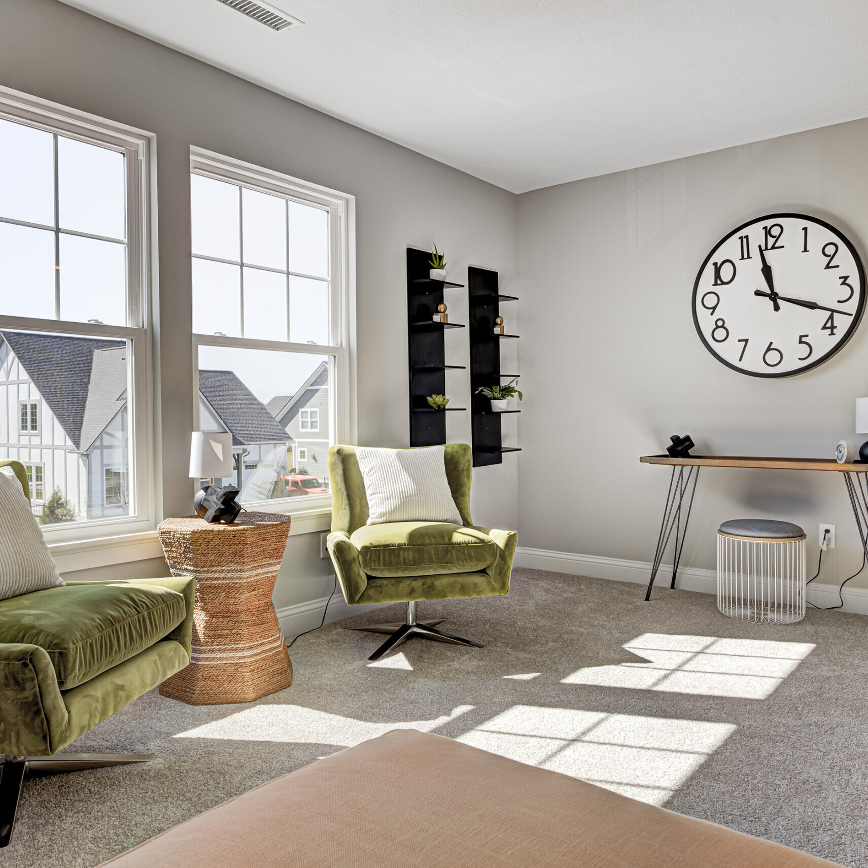A living room with a clock on the wall in a new custom home built by an Indianapolis custom homes builder.