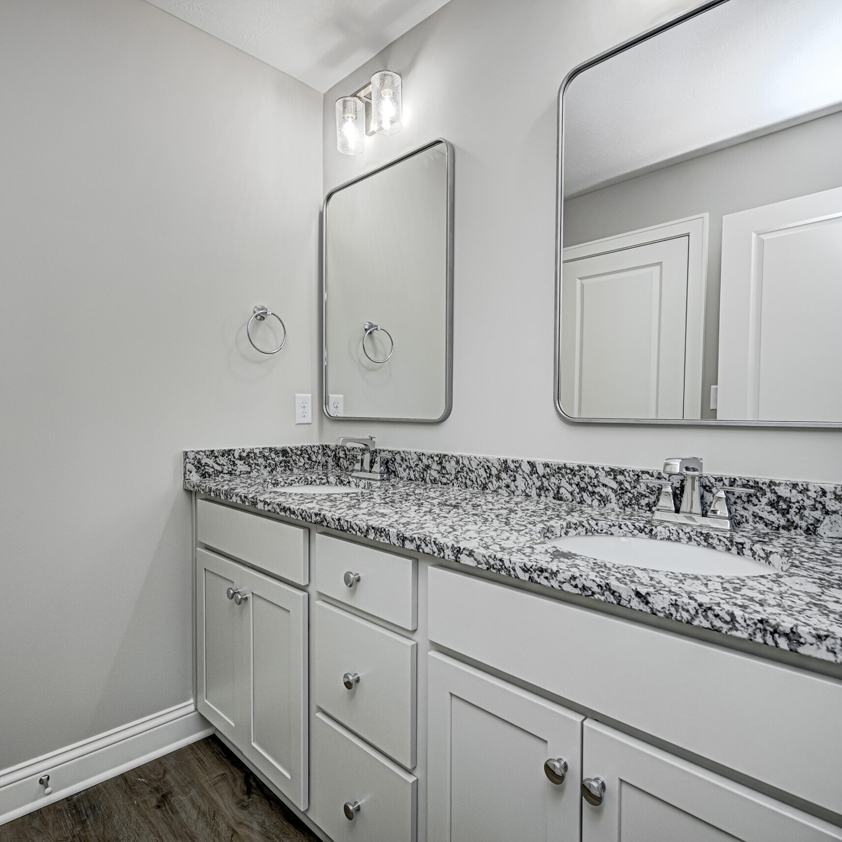 A bathroom with two sinks and granite counter tops, part of an Indianapolis custom home project.