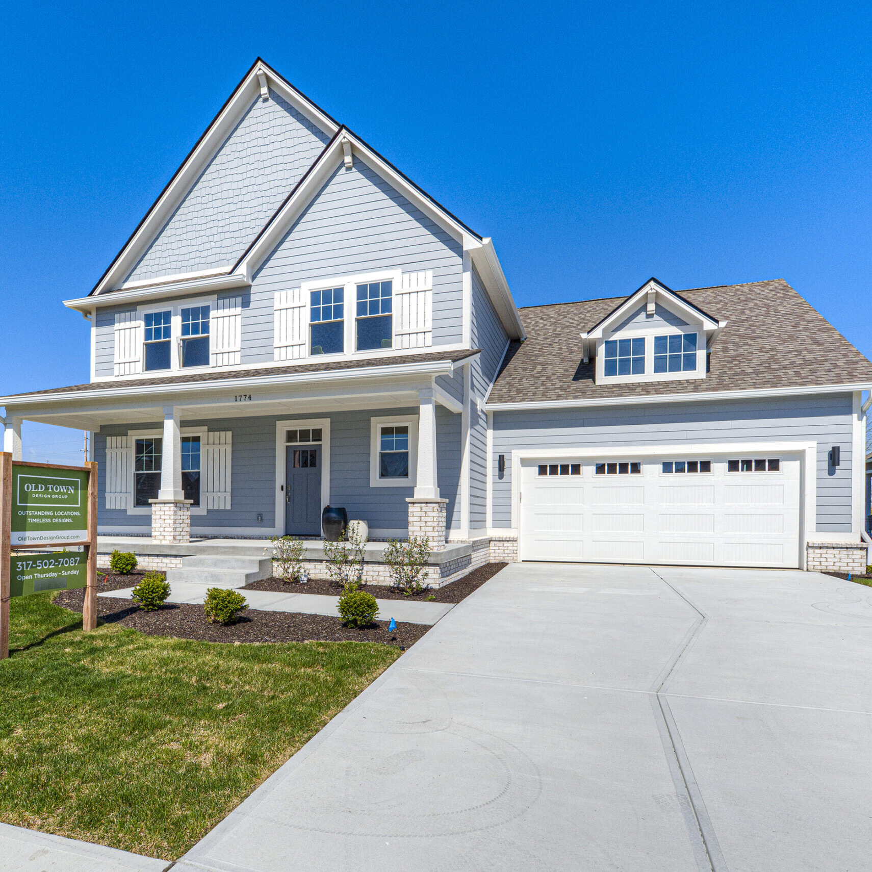 A two story home with a garage and driveway that is custom-built by the New Homes, Custom Home Builder Carmel Indiana.