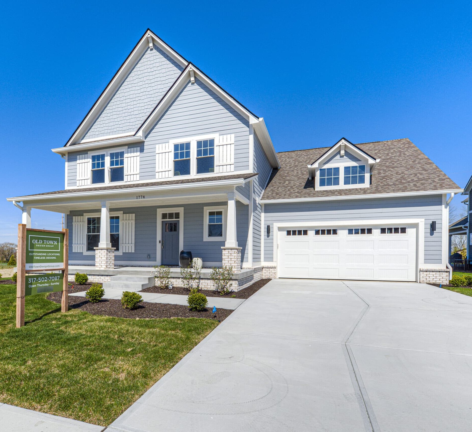 A two story home with a garage and driveway that is custom-built by the New Homes, Custom Home Builder Carmel Indiana.