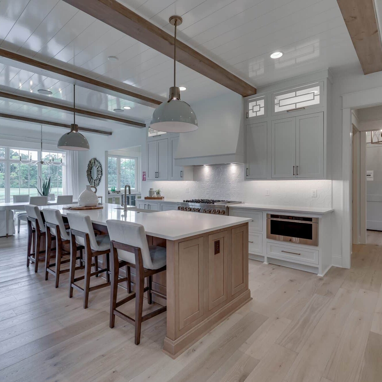 A large kitchen with wood beams and a center island.