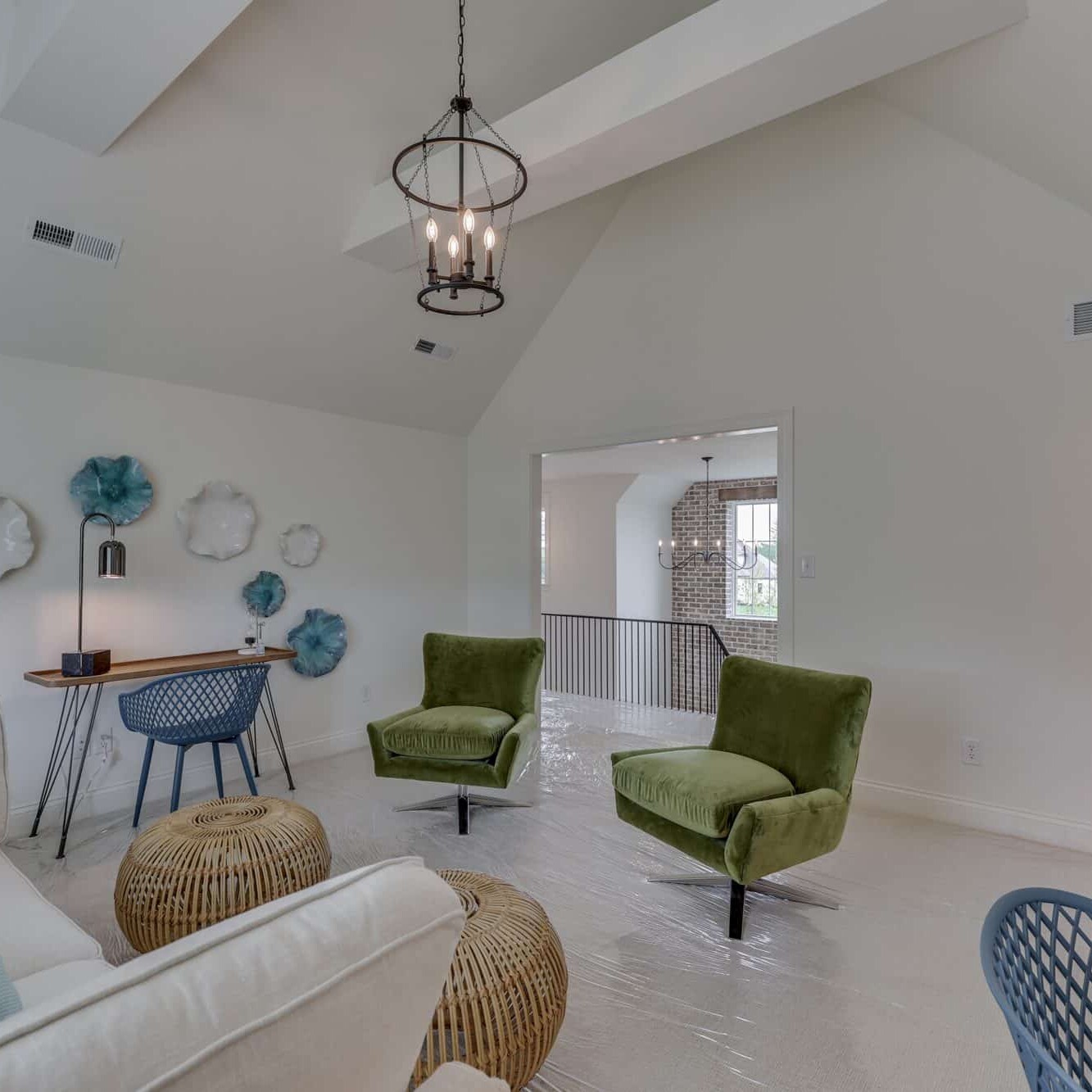 A living room with white walls and green chairs.