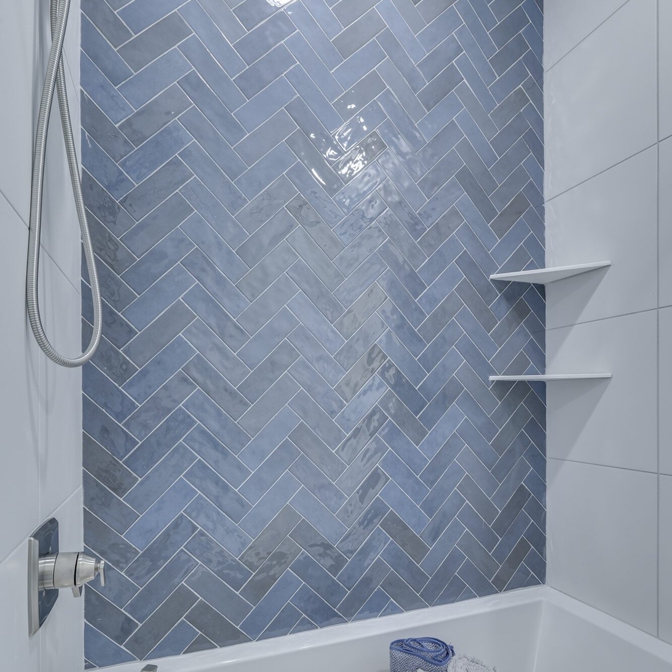 A bathroom with blue herringbone tile.