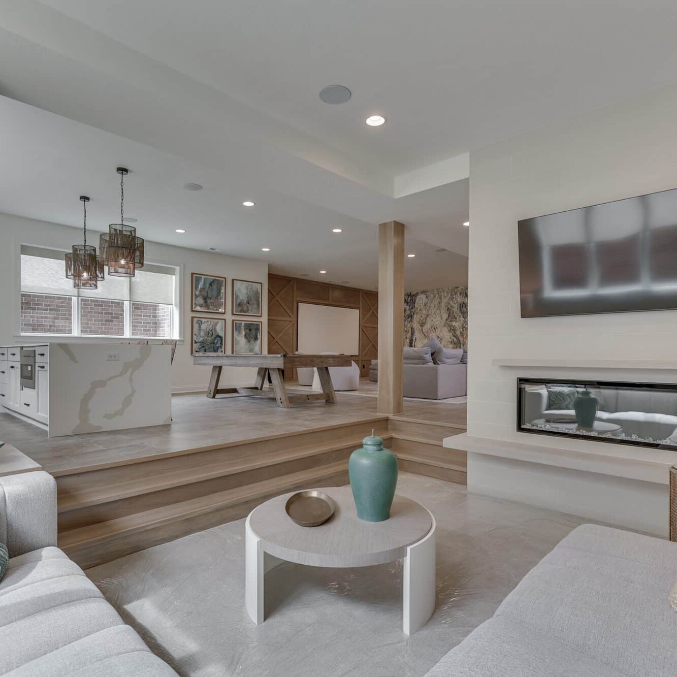 A living room with white furniture and a fireplace.