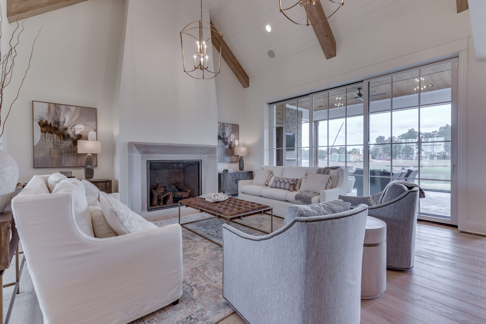 A living room with white furniture and a fireplace.