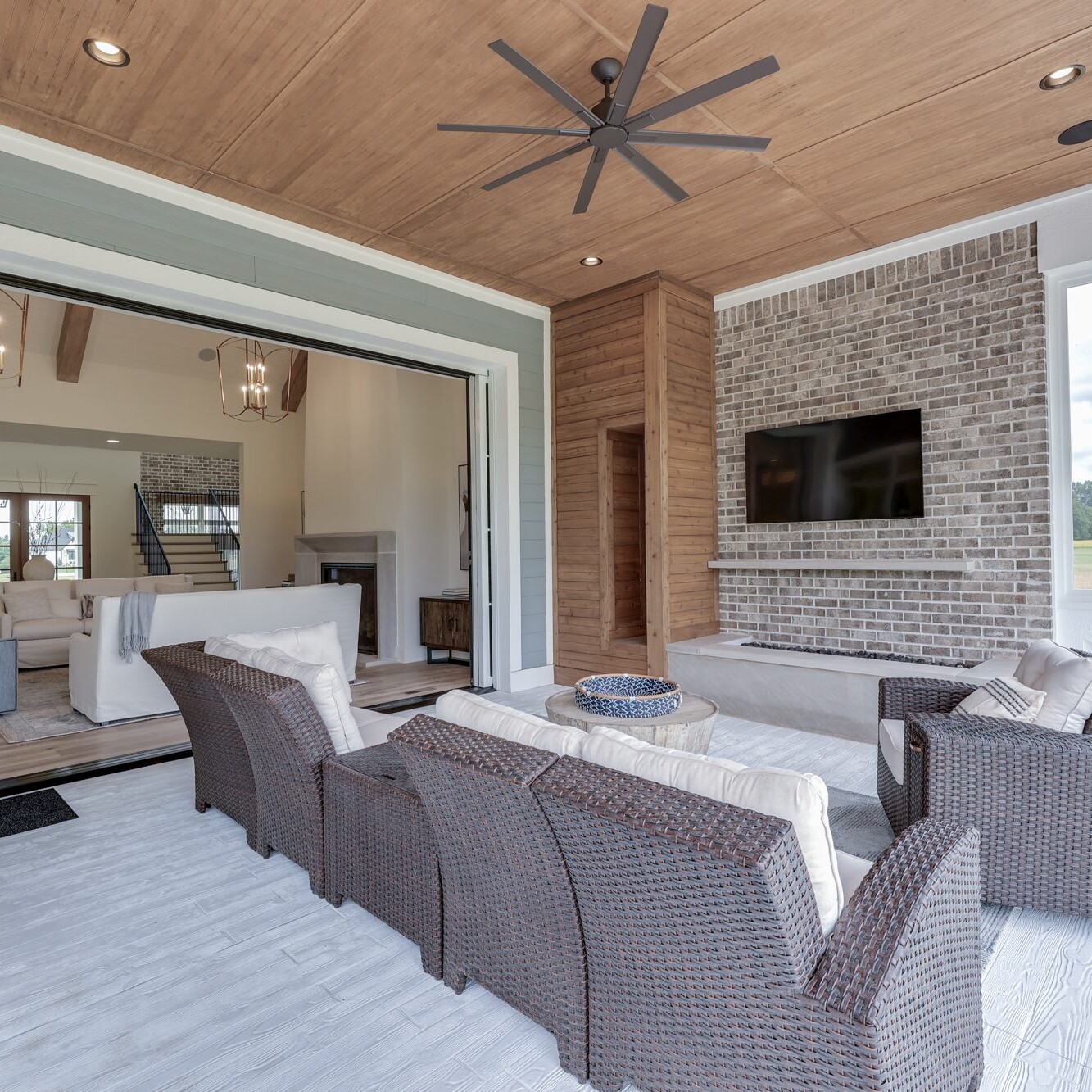 A living room with a fireplace and a ceiling fan.