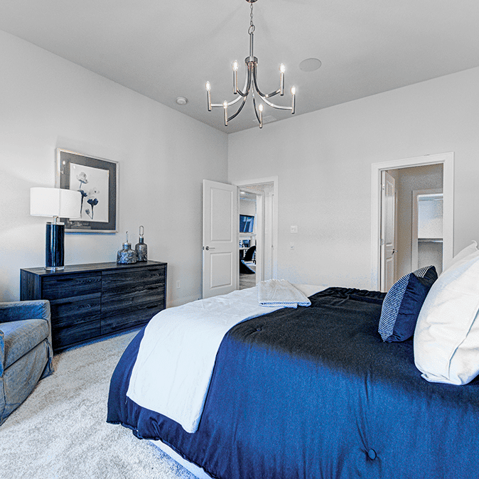 A blue and white bedroom with a chandelier.