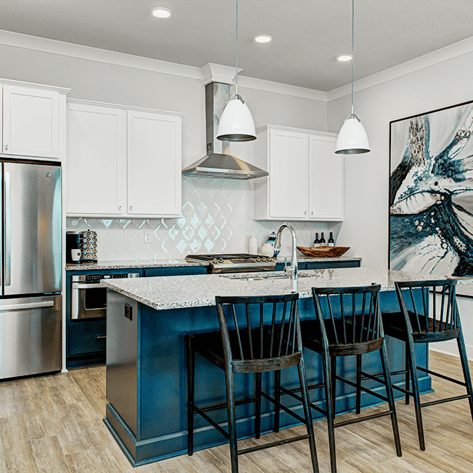 A kitchen with a blue island and stainless steel appliances.