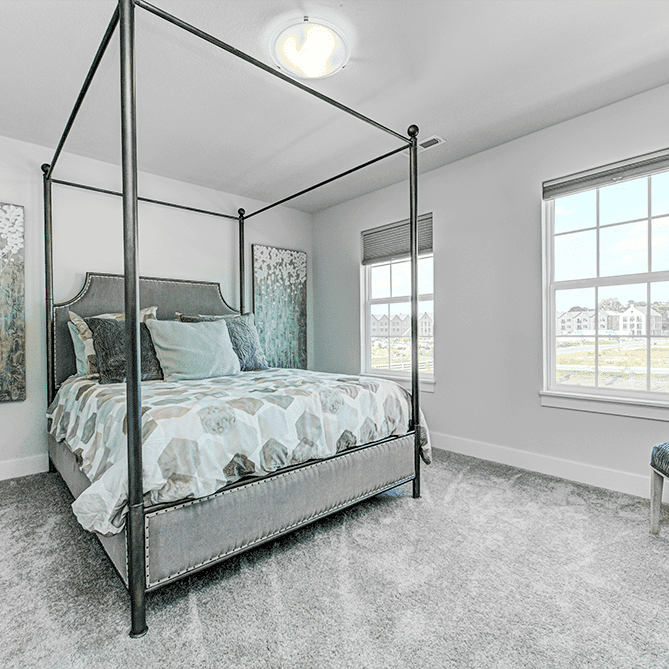 A gray bedroom with a four poster bed.