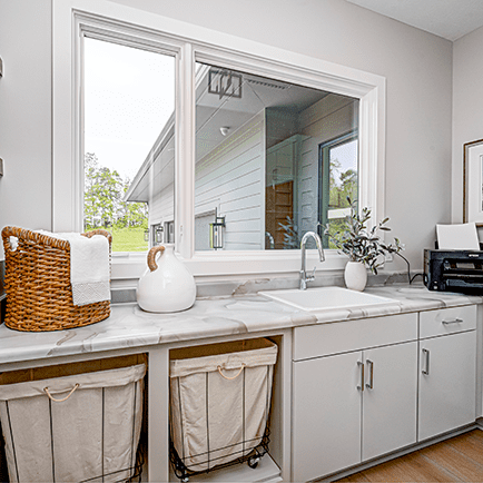 A laundry room with a sink and a window.