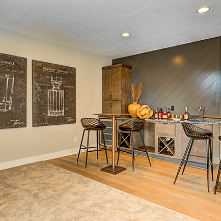 A room with a bar and stools.