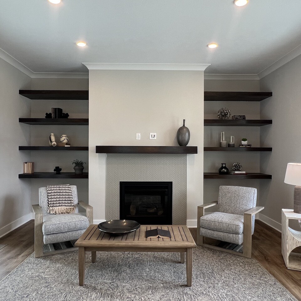 A cozy living room featuring a fireplace, bookshelves, and the finest craftsmanship from a top custom home builder serving Westfield and Carmel in Indiana.