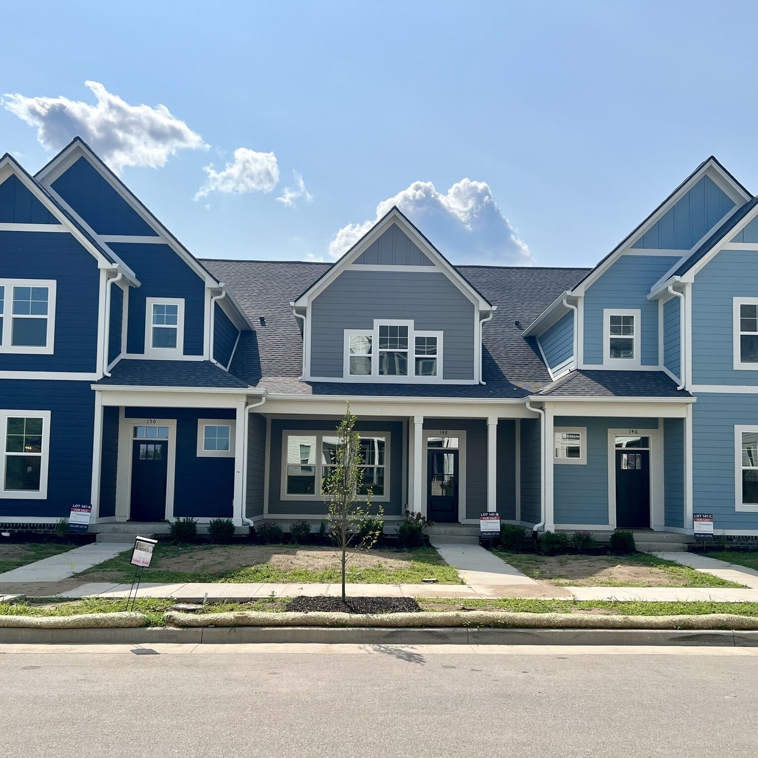 A row of blue and white townhouses on a street, custom-built by a Luxury custom home builder Westfield Indiana.