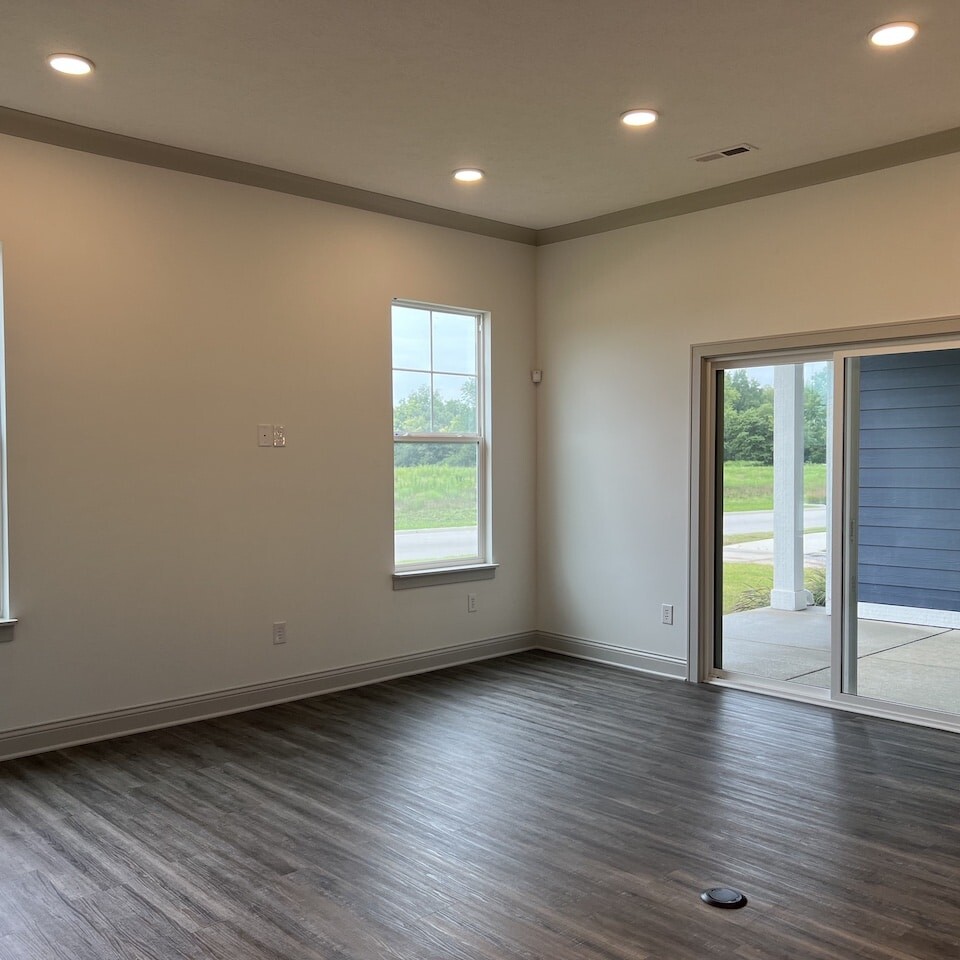 Spacious living room with hardwood floors and sliding glass doors, perfect for new homes in Carmel Indiana.