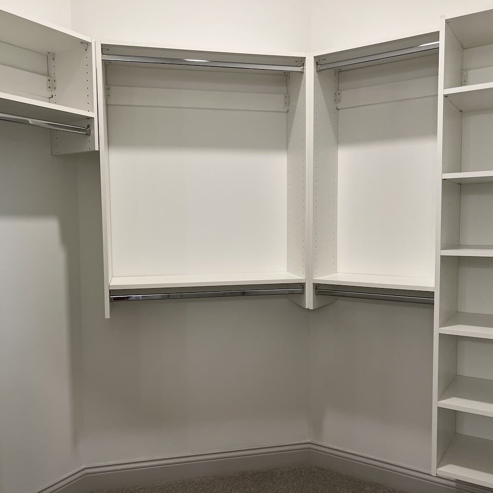 A luxurious white walk-in closet with shelves and drawers, perfectly suited for new homes in Carmel Indiana or custom homes built by a luxury custom home builder in Westfield Indiana.
