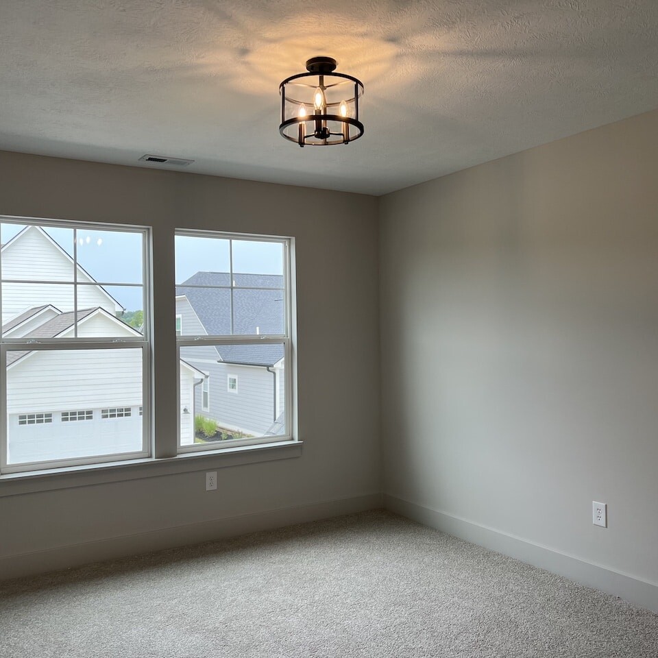 A spacious room with a window and a light fixture.