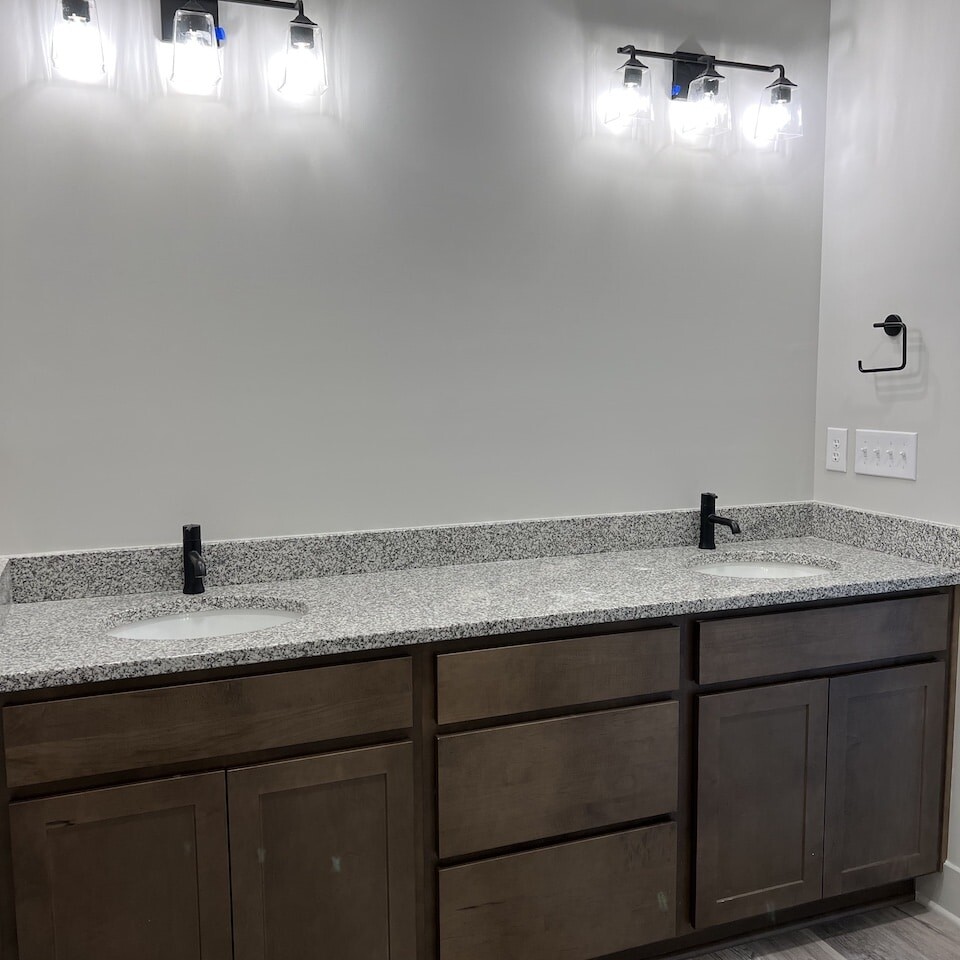 Two sinks in a bathroom with granite counter tops, perfect for luxurious custom homes.