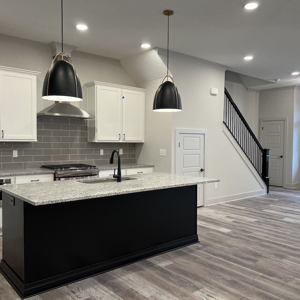 A luxury custom home builder in Westfield Indiana creating new homes for sale in Carmel Indiana and Fishers Indiana. This stunning kitchen features white cabinets and black counter tops, adding sophistication to the