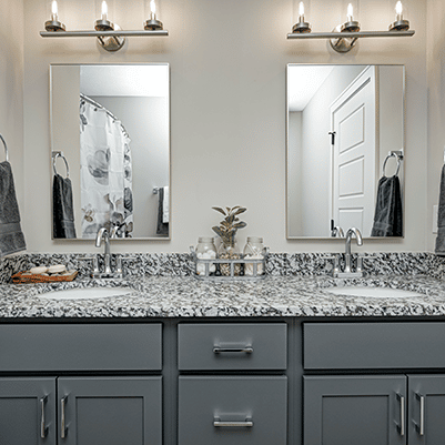 A bathroom with two sinks and a mirror.