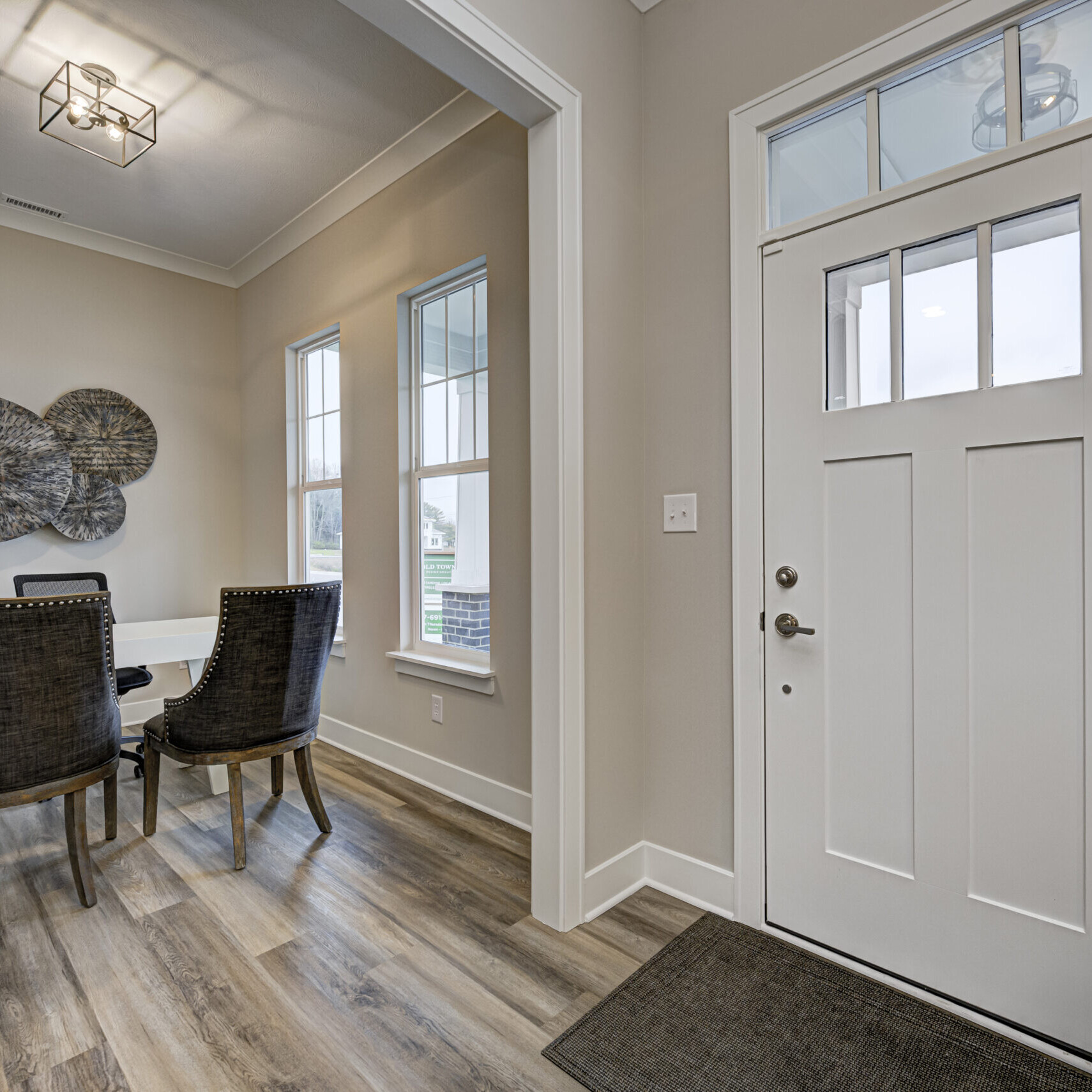 A dining room with hardwood floors and a white door, located in a custom home in Westfield, Indiana.