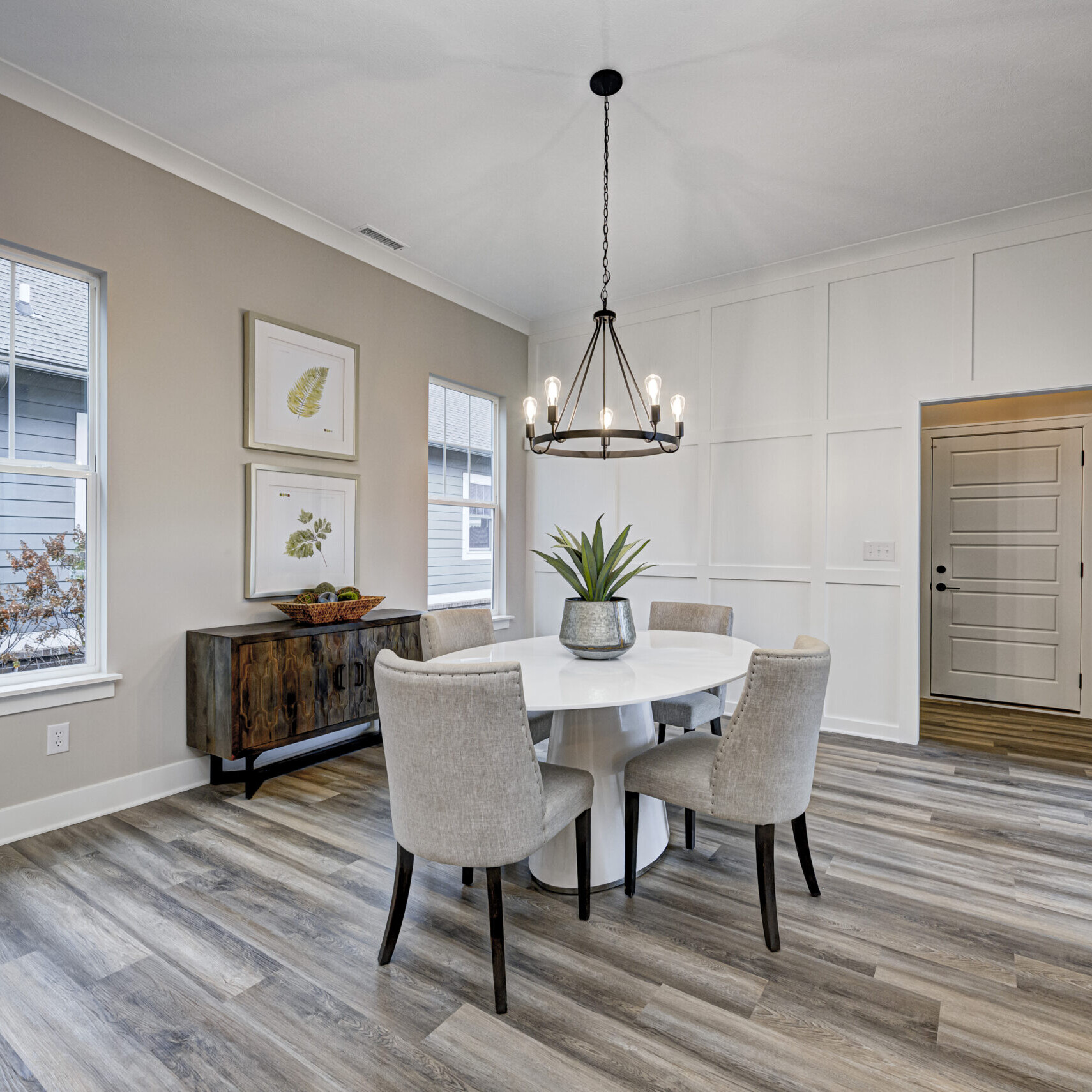 A dining room with hardwood floors and white walls, built by a Custom Home Builder in Carmel Indiana.