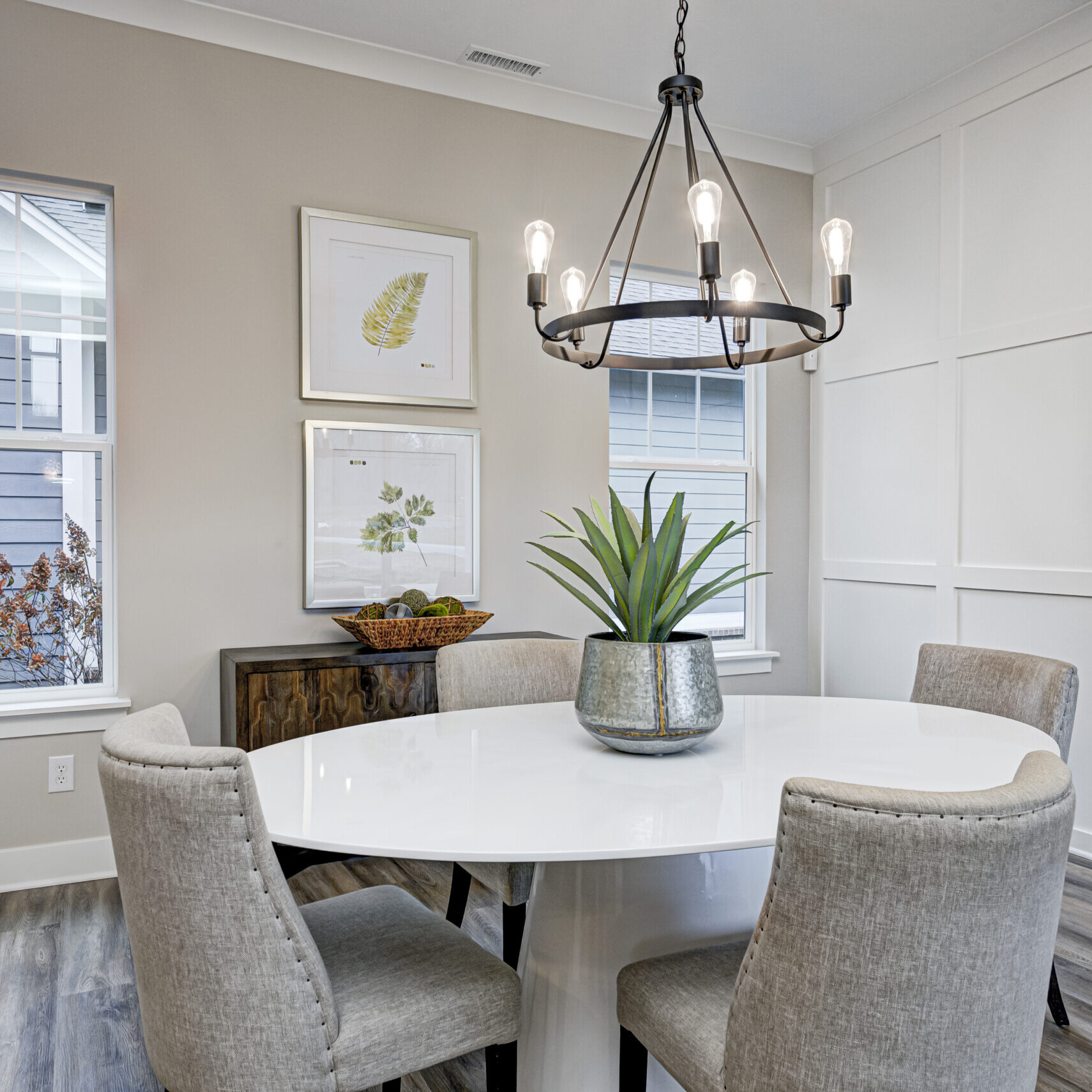 A dining room with a white table and chairs designed and built by a Custom Home Builder Fishers Indiana.
