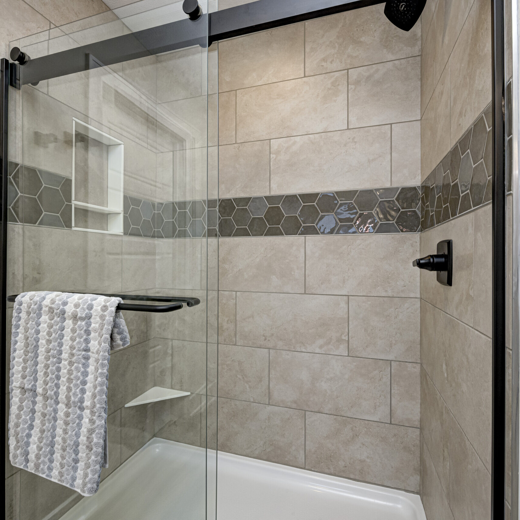 A bathroom with a glass shower door and a towel rack, designed by a Custom Home Builder in Indiana.