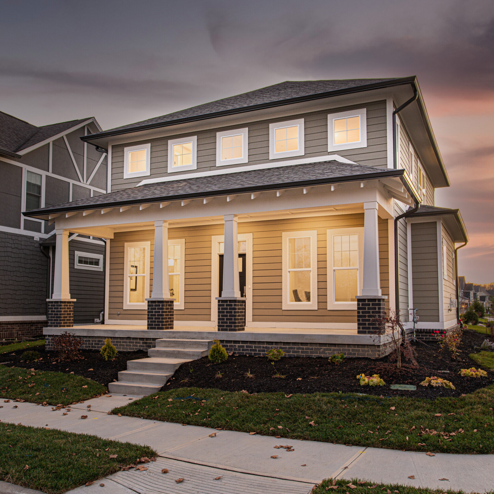 A custom home with a front porch at dusk in Westfield, Indiana.