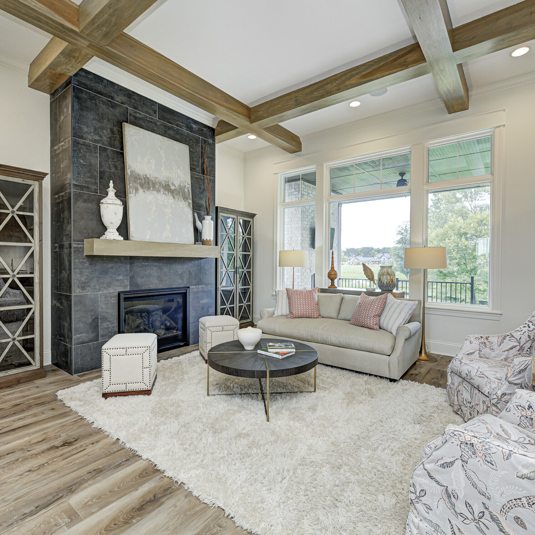 A living room with wood beams and a fireplace in a custom home.