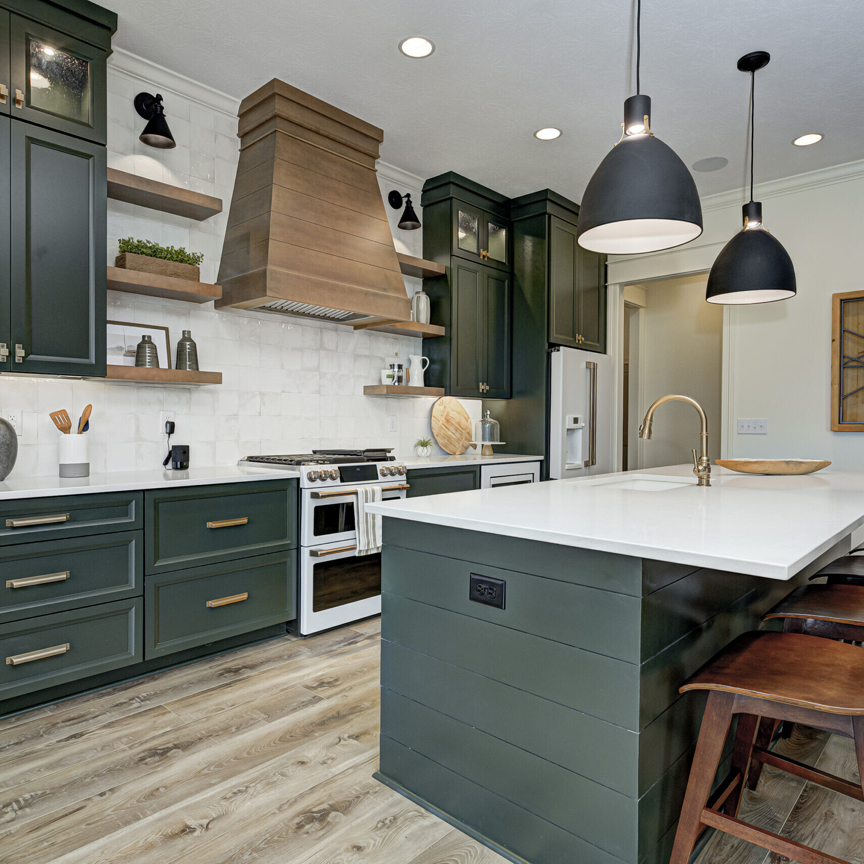 A custom kitchen with green cabinets and a center island, designed by an Indianapolis custom home builder.