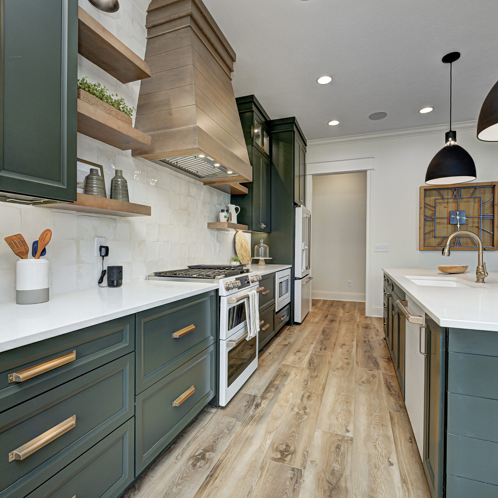 A custom home kitchen in Indianapolis, Indiana with green cabinets and wood floors.