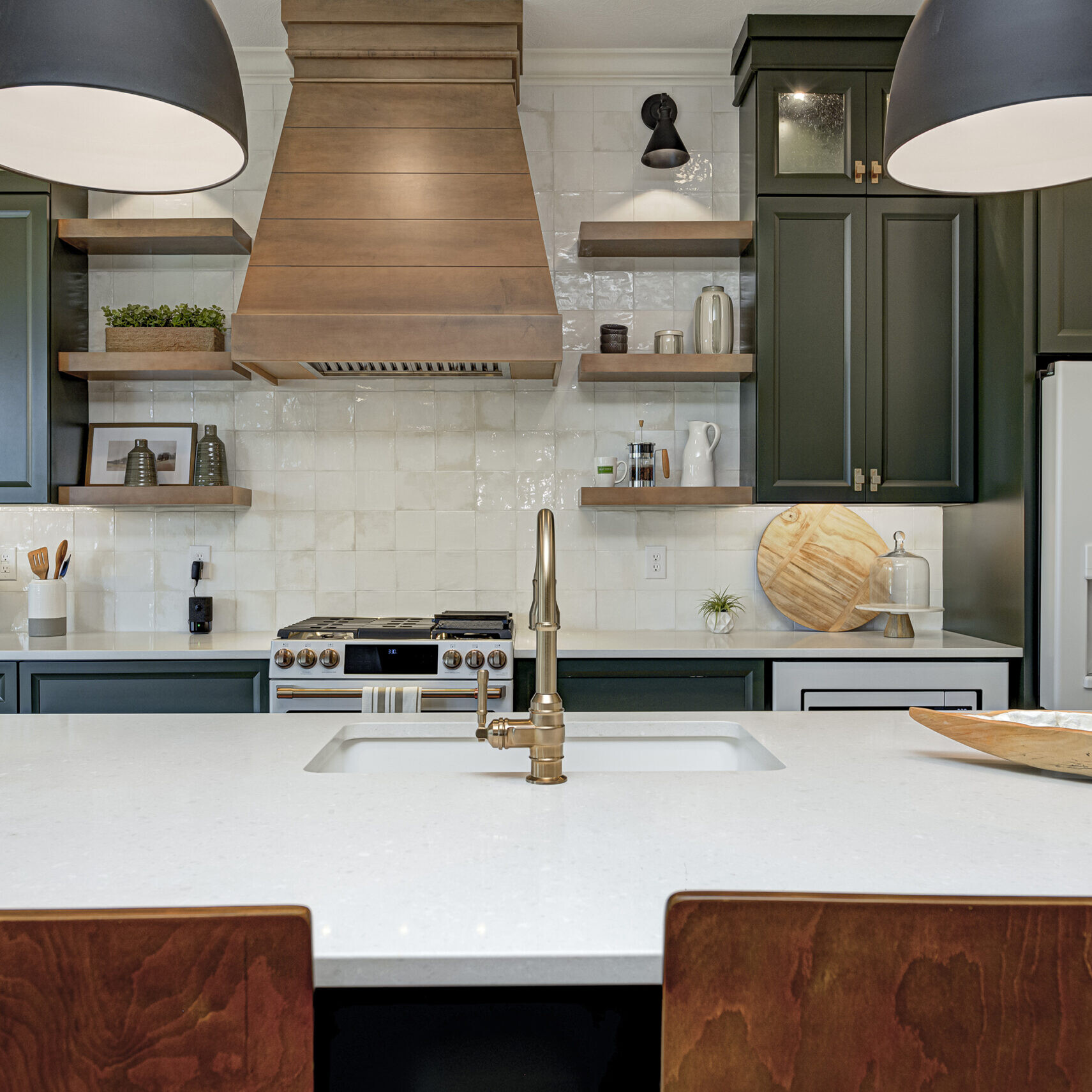 A kitchen with a white counter top and green cabinets designed by an Indianapolis custom home builder.