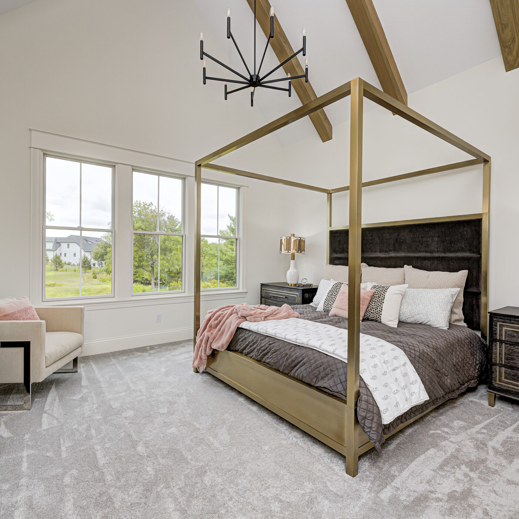 A bedroom with a four poster bed and a chandelier, designed by an Indianapolis Custom Home Builder.