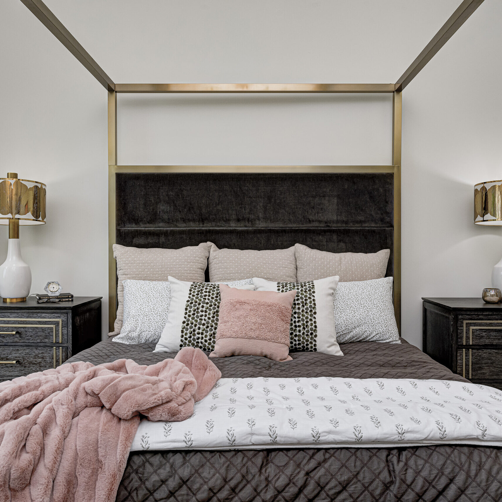 A bedroom with a gold canopy bed and pink pillows, custom built by a leading custom home builder in Carmel, Indiana.