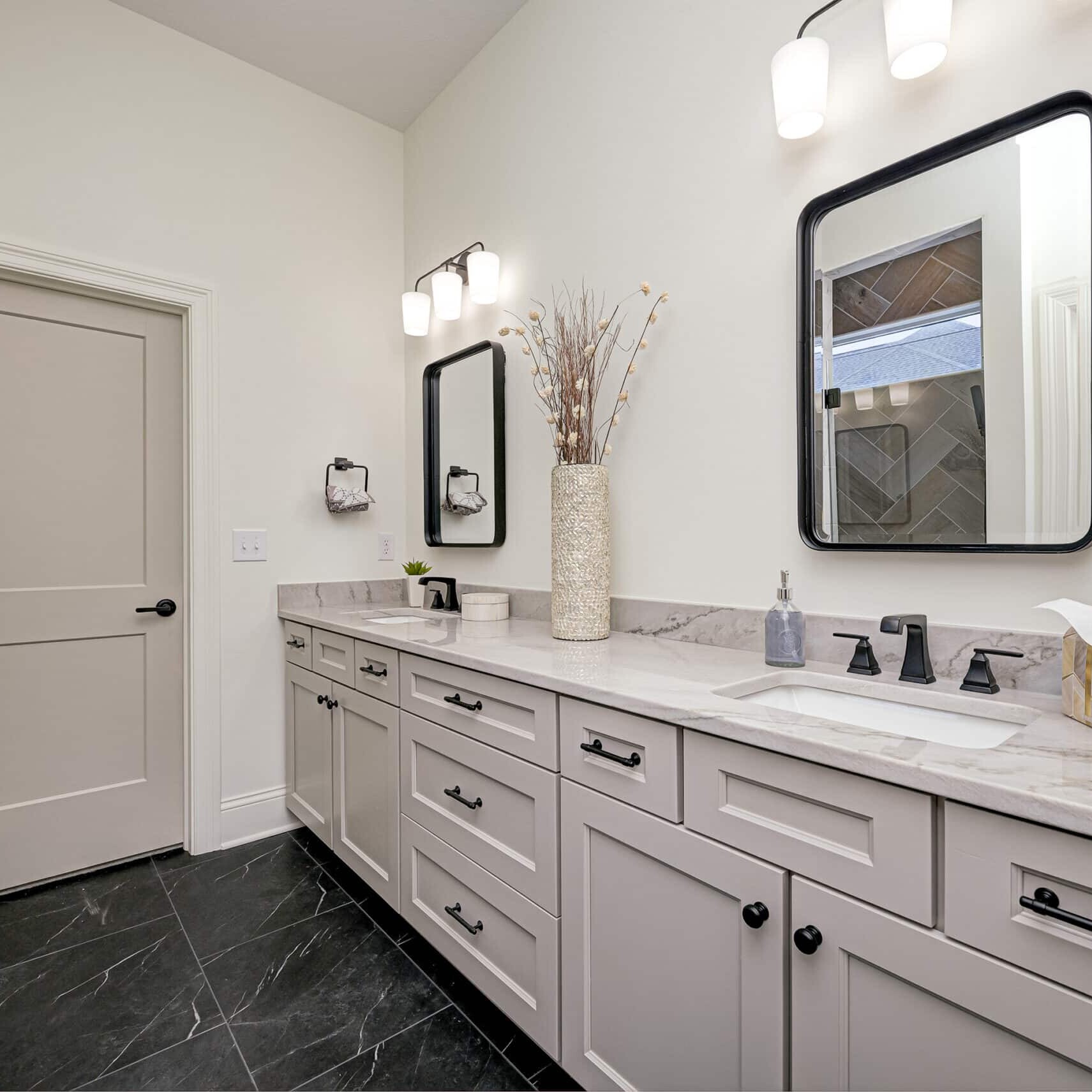 A custom home bathroom in Carmel, Indiana featuring two sinks and a mirror.