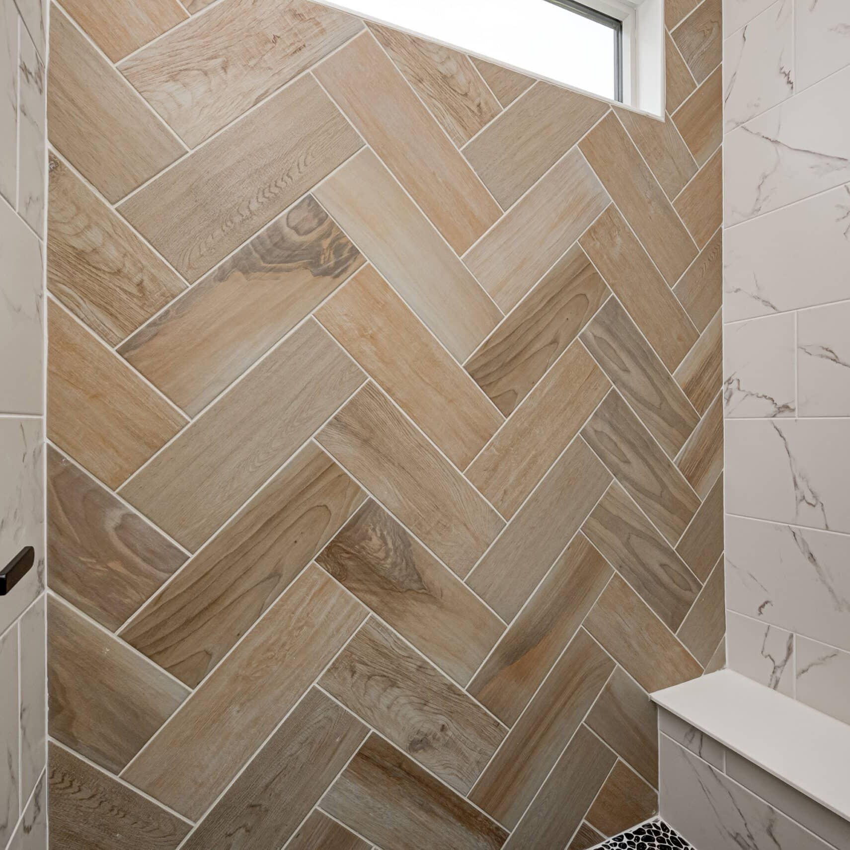 A herringbone tiled shower in a custom home.