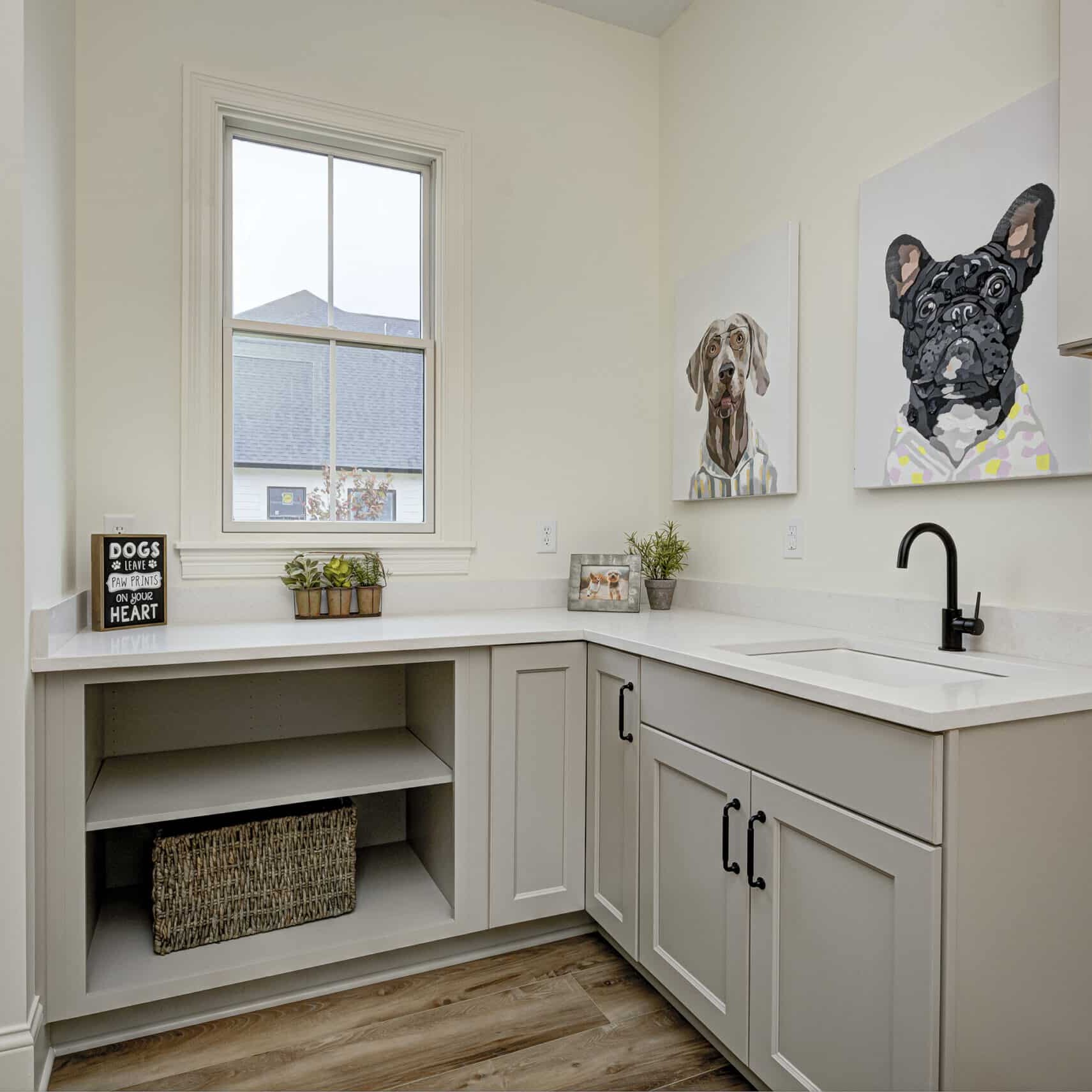 A laundry room with a sink and a picture of a dog, designed by Custom Home Builder Carmel Indiana.