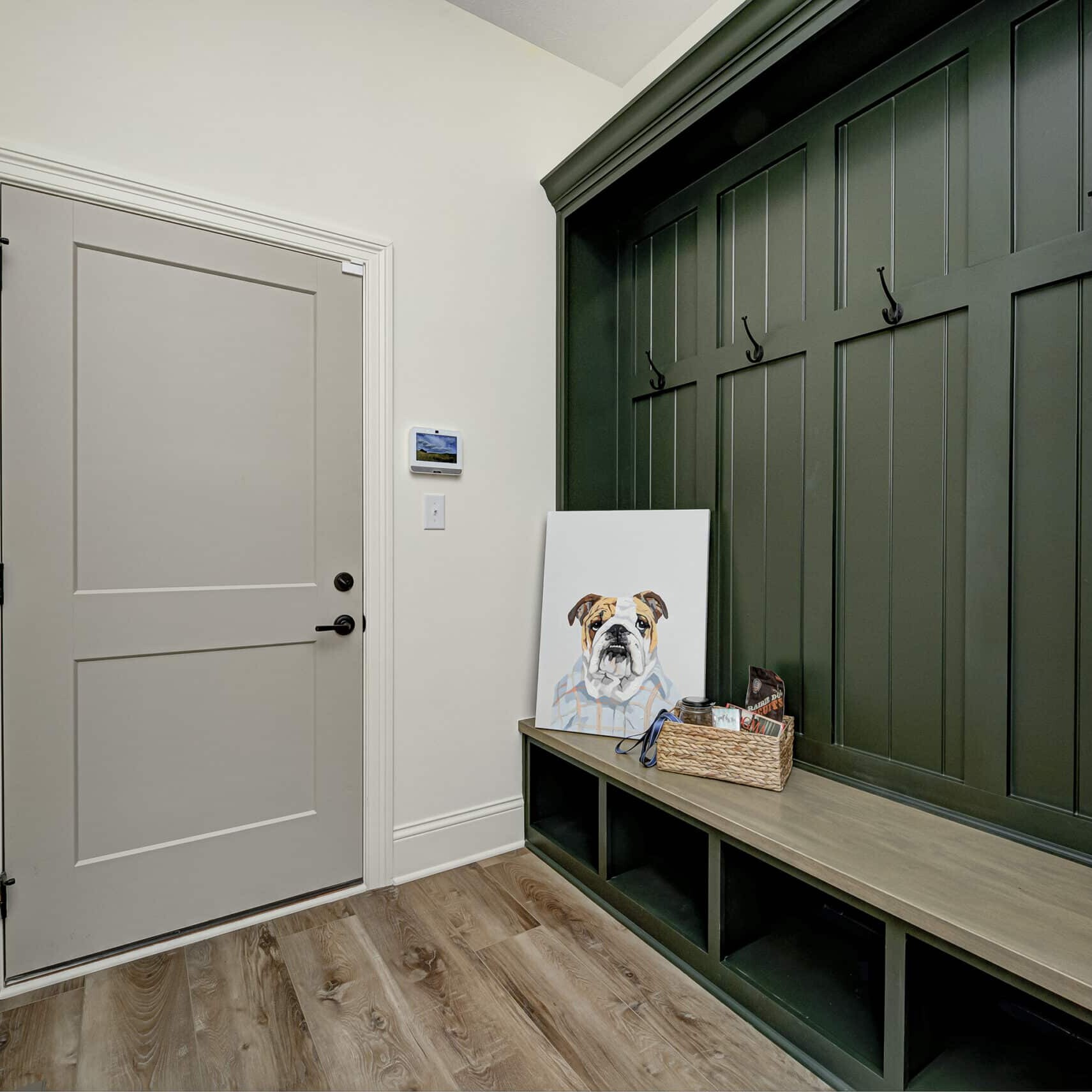 A new custom home in Fishers Indiana with a mudroom featuring a bench and a green door.