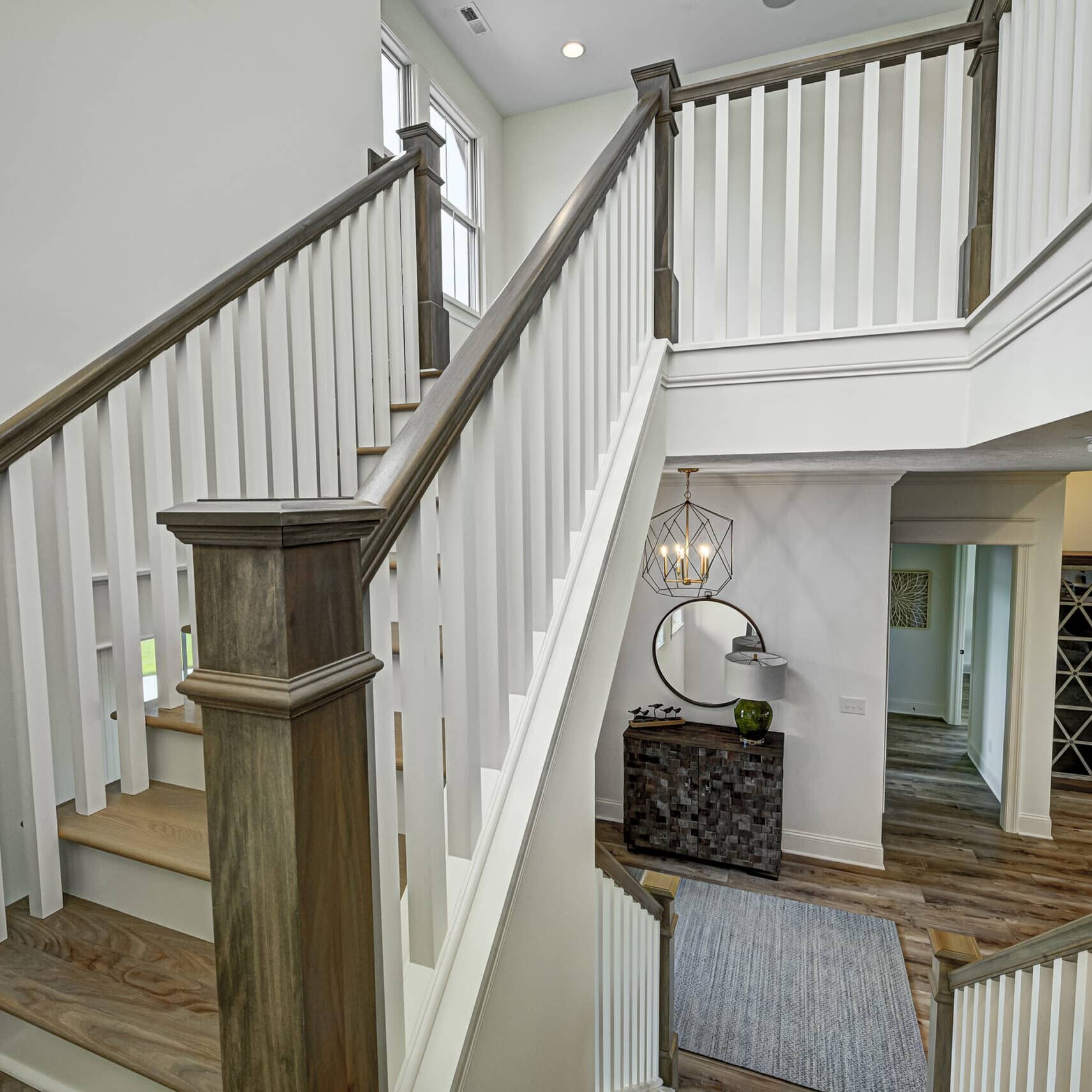 A beautifully-designed stairway in a custom home with white railings.