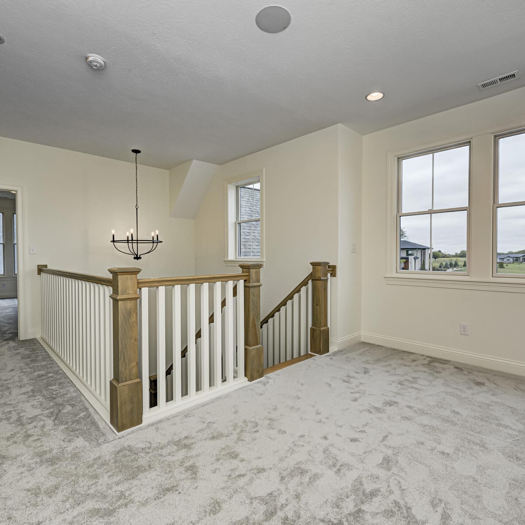 A custom home builder in Fishers, Indiana designed a beautiful staircase in a newly built home. The staircase features elegant white carpet and stunning windows, highlighting the craftsmanship of the custom homes in West