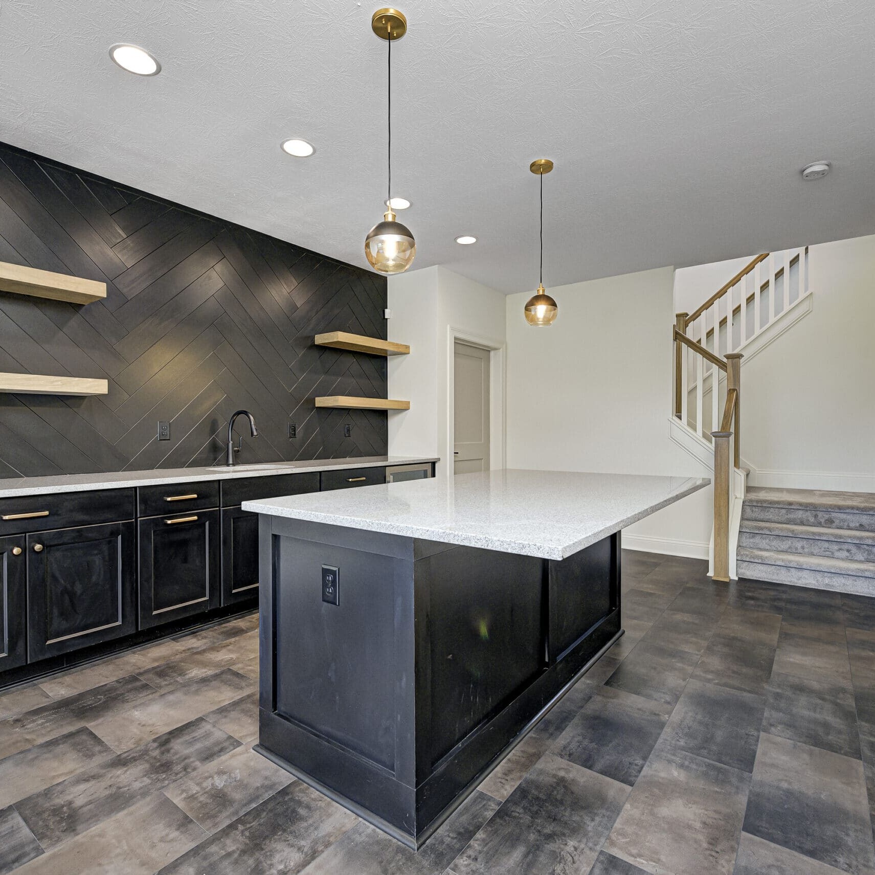 Keywords: Custom Home Builder Carmel Indiana, Custom Home Builder Fishers Indiana

Description: A kitchen with black cabinets and wood floors designed by a skilled custom home builder in Carmel and Fishers,