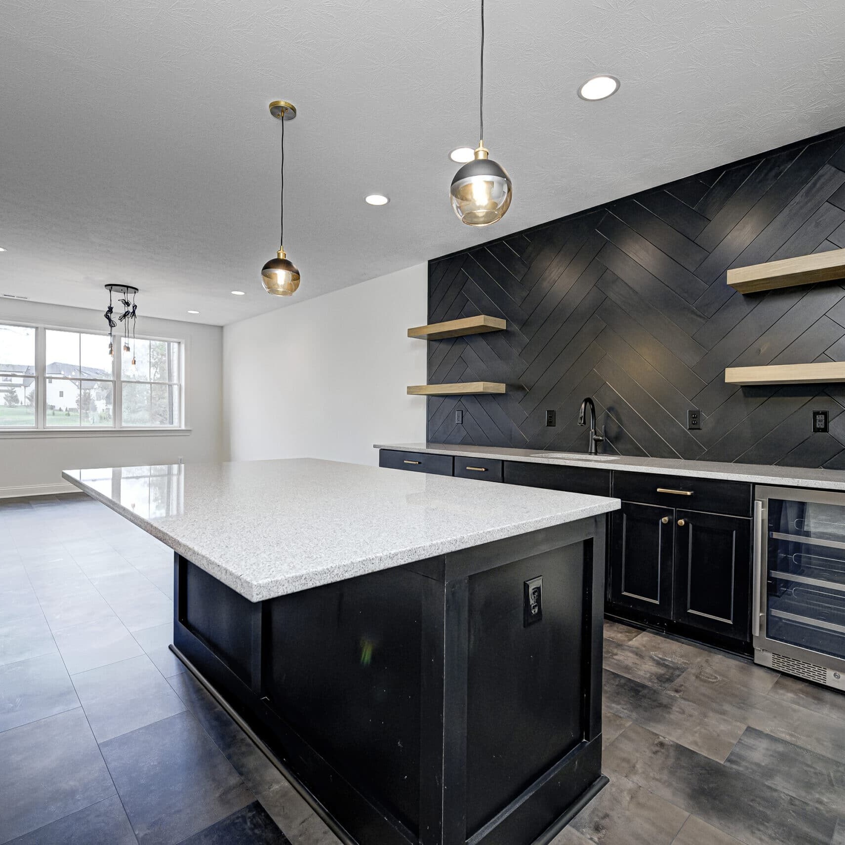 A kitchen with black cabinets and a black island, perfect for homeowners looking to add a touch of elegance and sophistication to their new custom home.