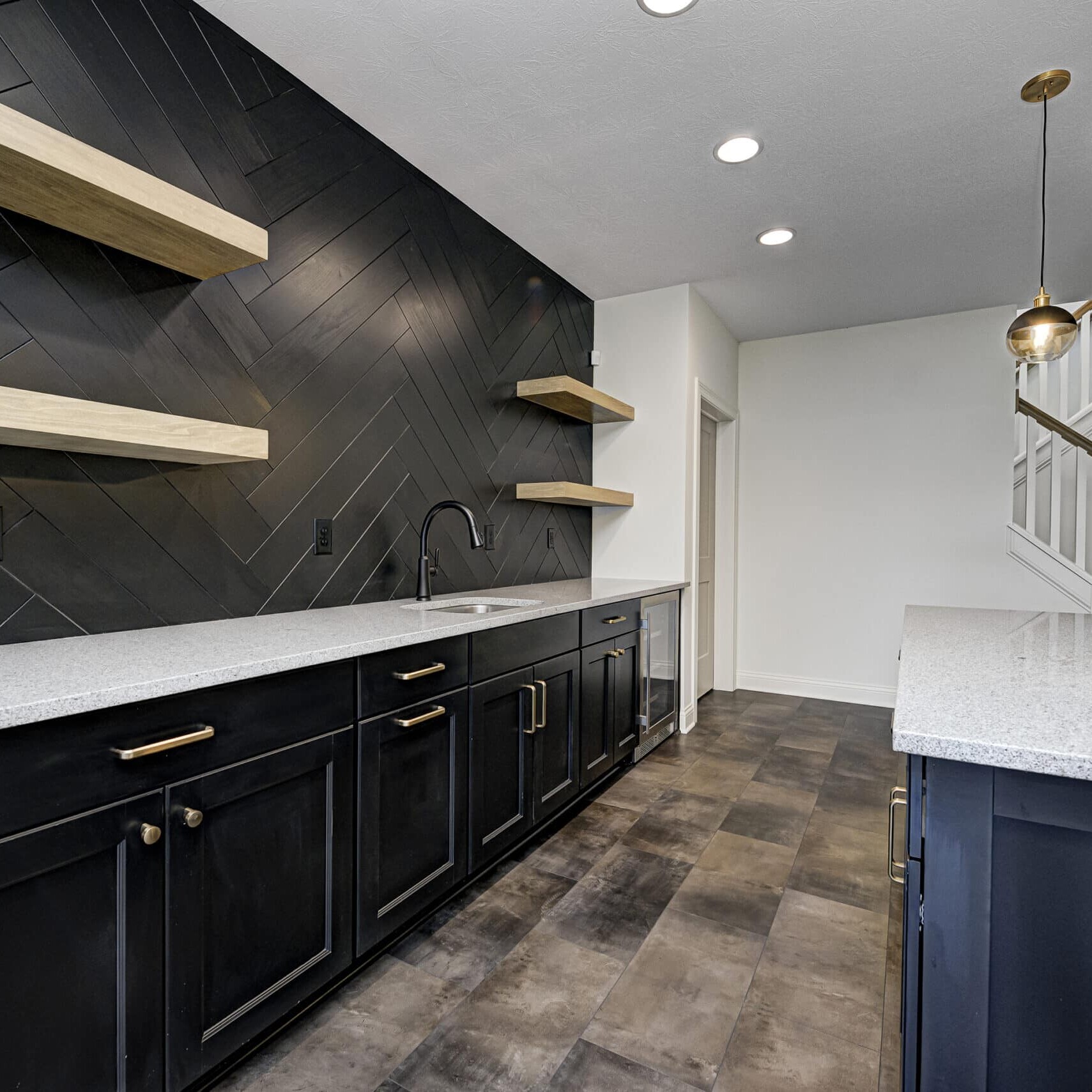 A kitchen with black cabinets, black counter tops, and custom home builder Fishers Indiana.