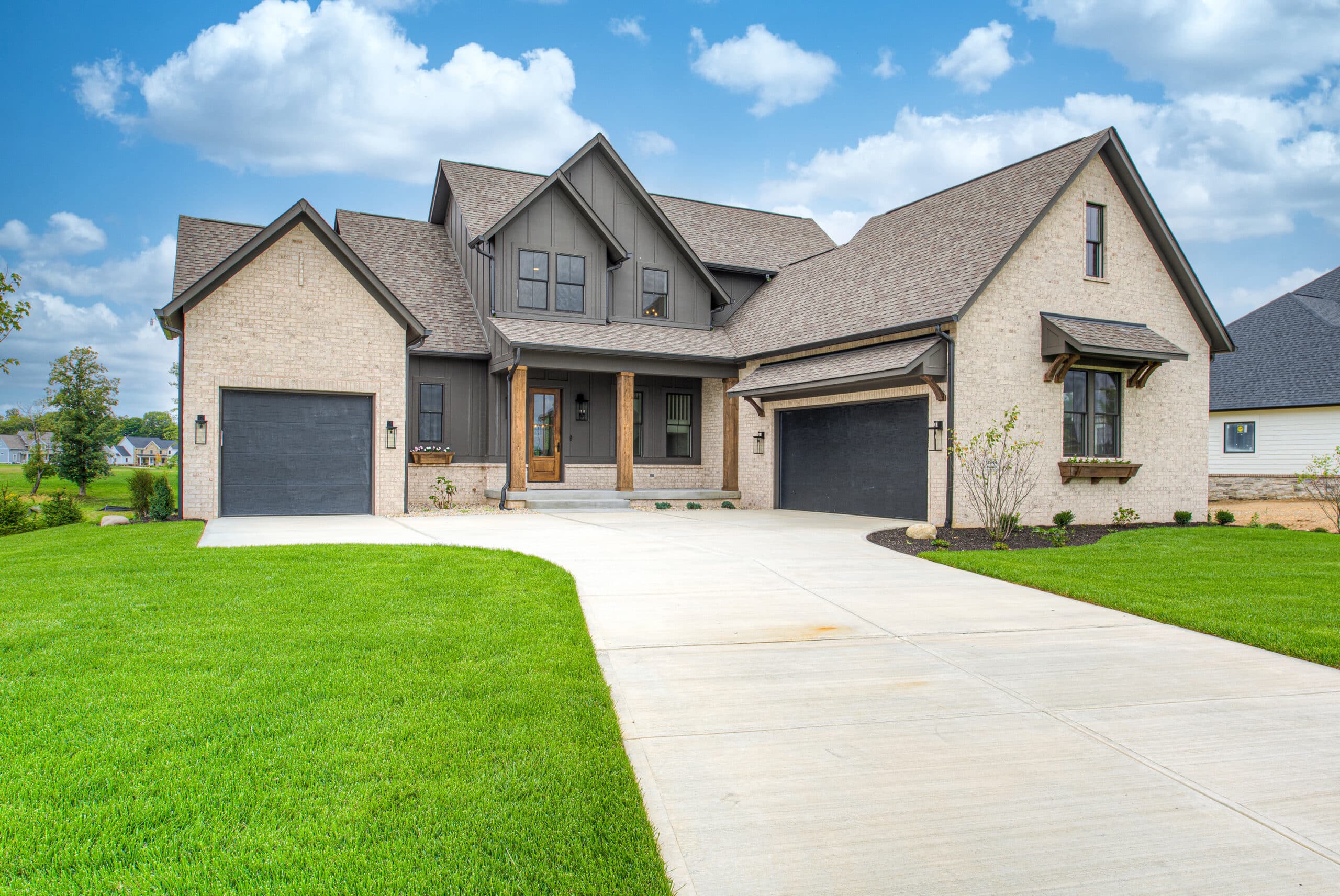 A newly built home with a garage and driveway, constructed by a custom home builder in Fishers, Indiana.