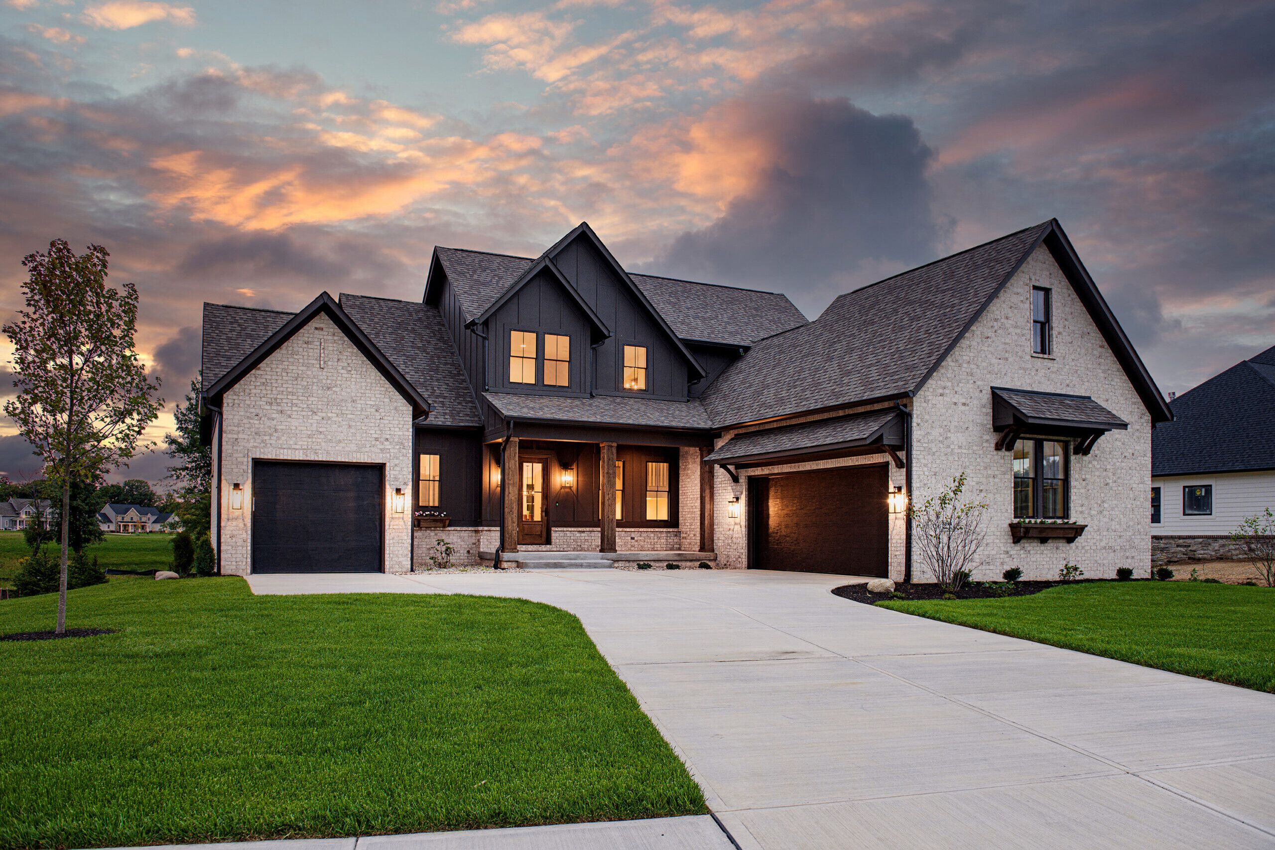 A custom home with a driveway and garage at dusk in Carmel, Indiana, or Fishers, Indiana.