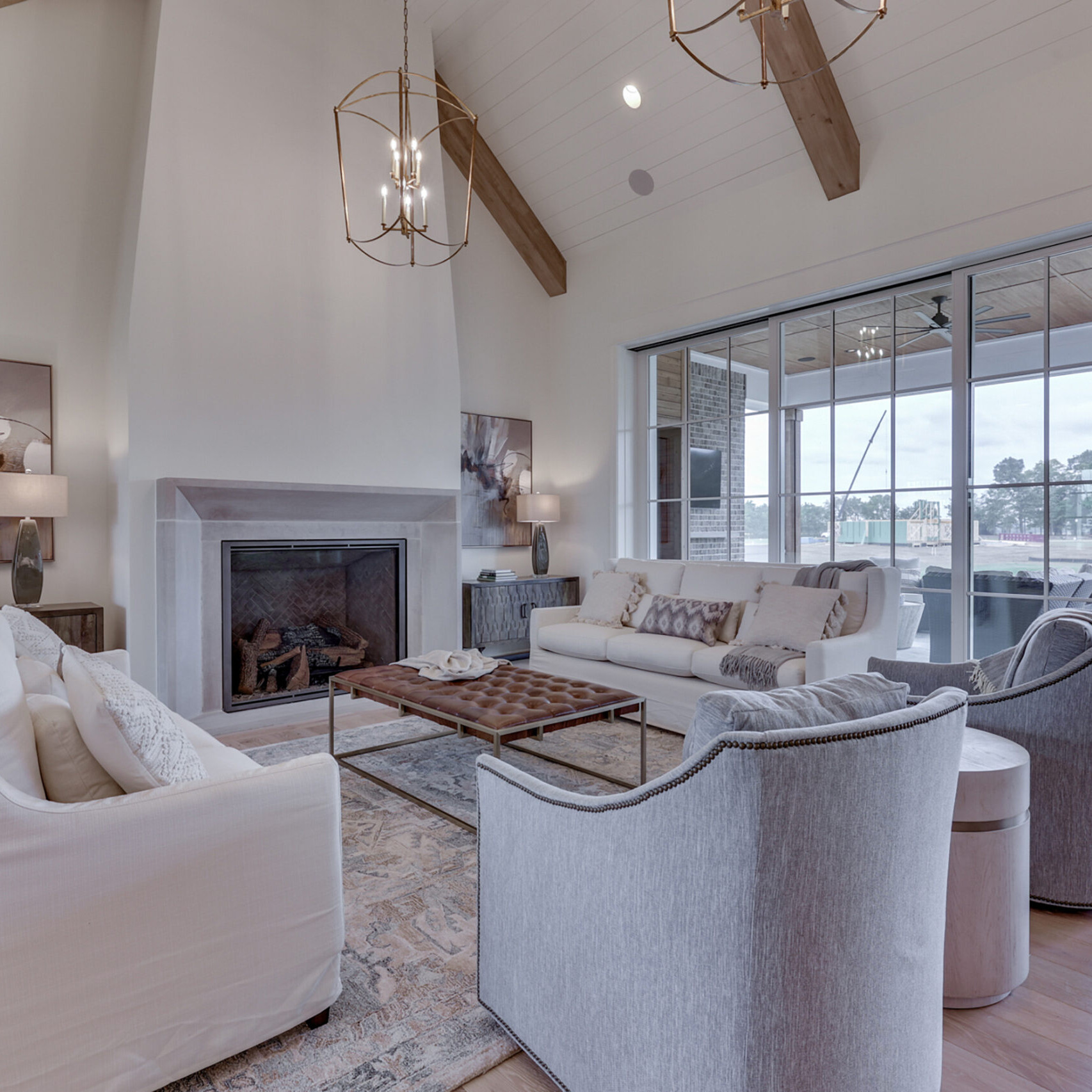 A living room with wood beams and a fireplace, crafted by a Custom Home Builder in Carmel Indiana.