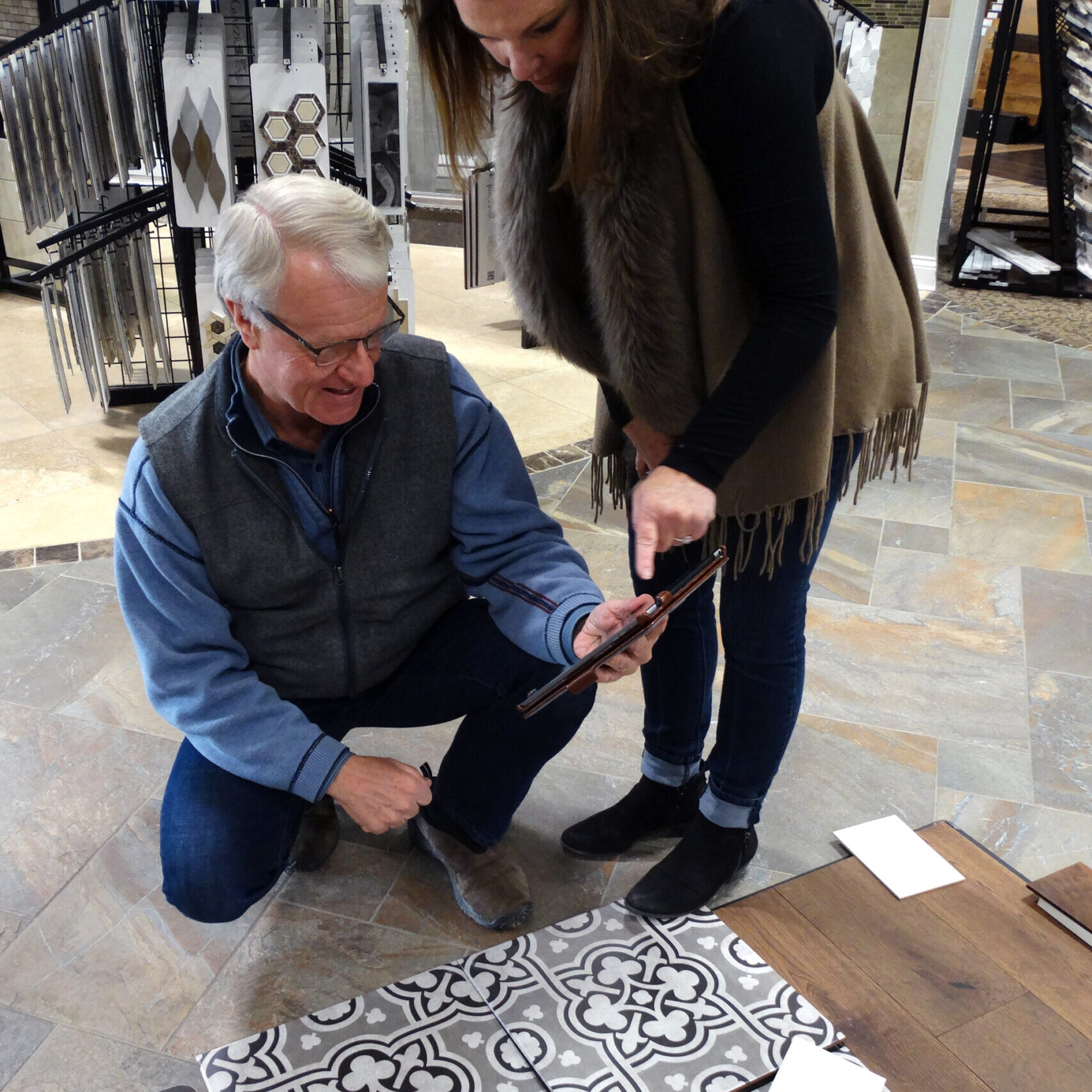 A man and a woman examining a tile in a home store.