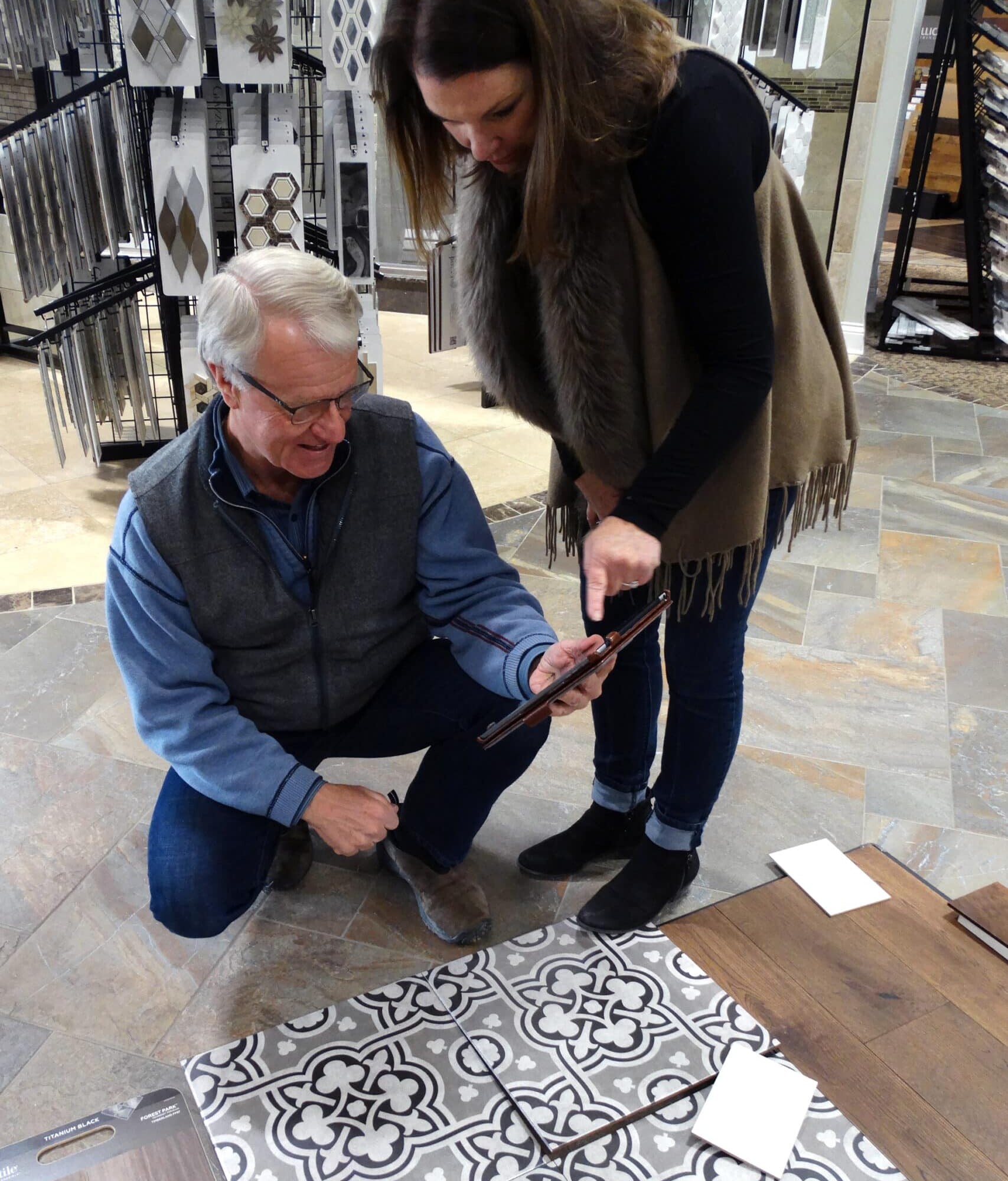 A man and a woman examining a tile in a home store.