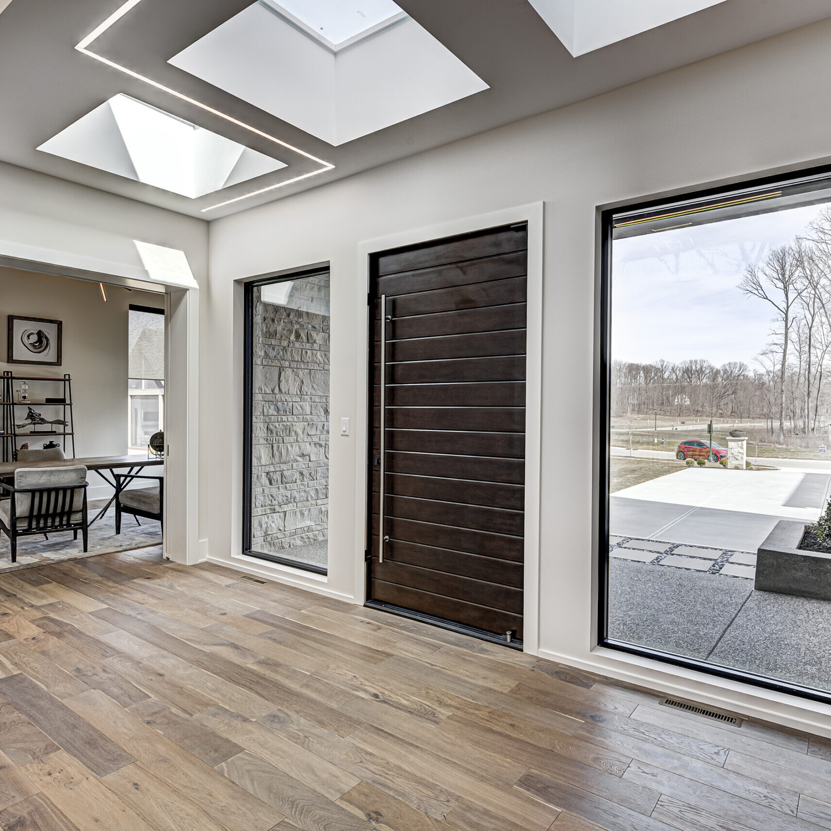 An entryway with a skylight and hardwood floors.