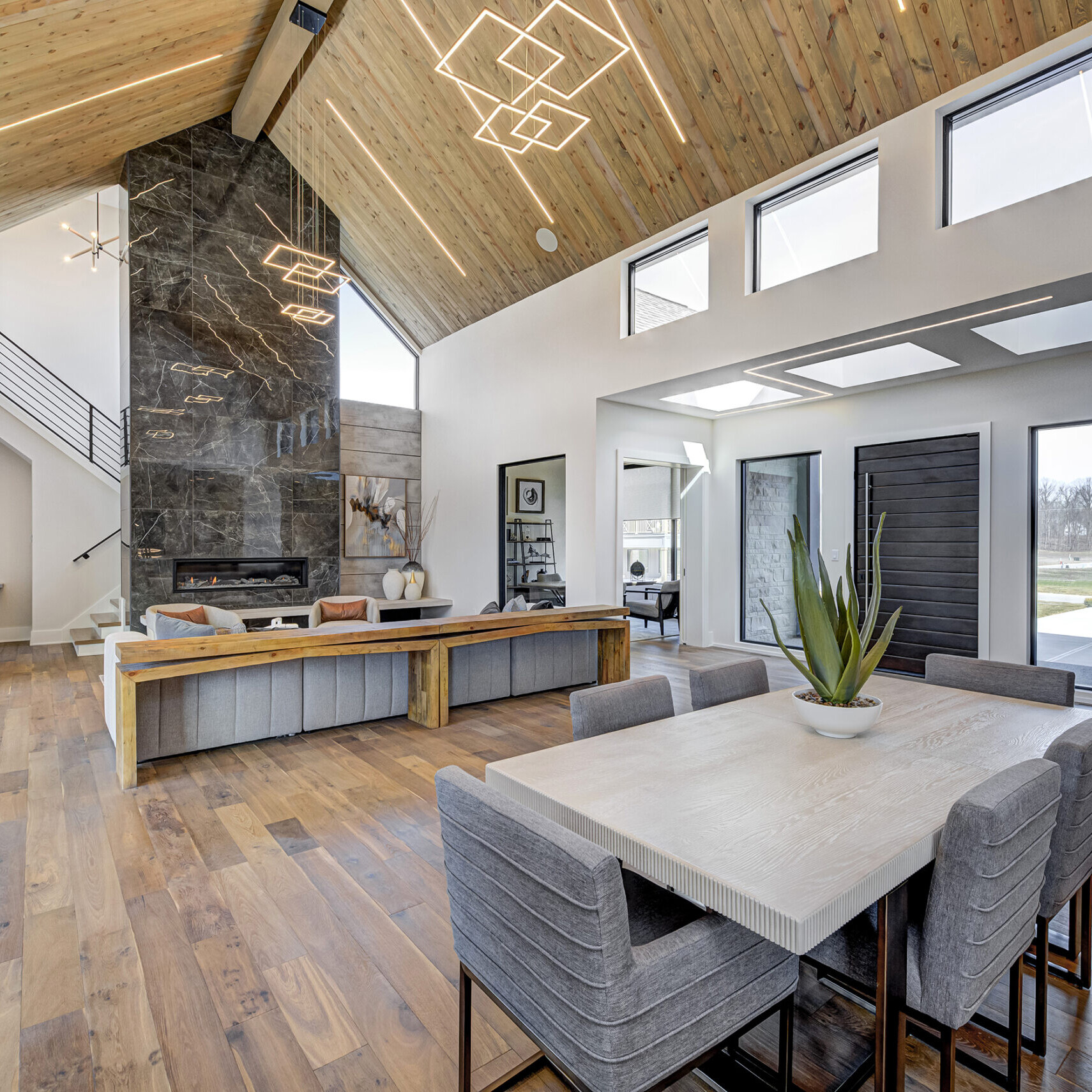 A modern kitchen and dining room with a vaulted ceiling.